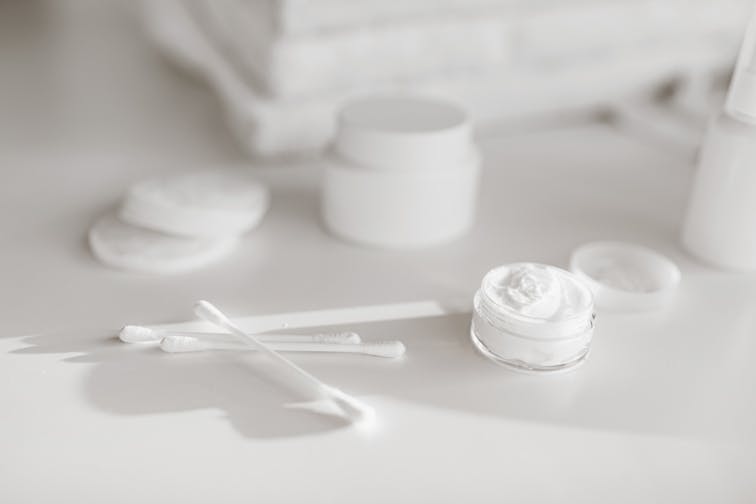 保湿クリームやローションのボトルが並んでいる、スキンケアアイテムのイメージ写真。清潔感のある白い背景