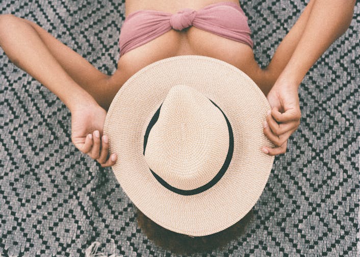 日焼け止めやUVケアのイメージ。帽子や日傘と一緒に日焼け止めが写っている、明るく爽やかな写真