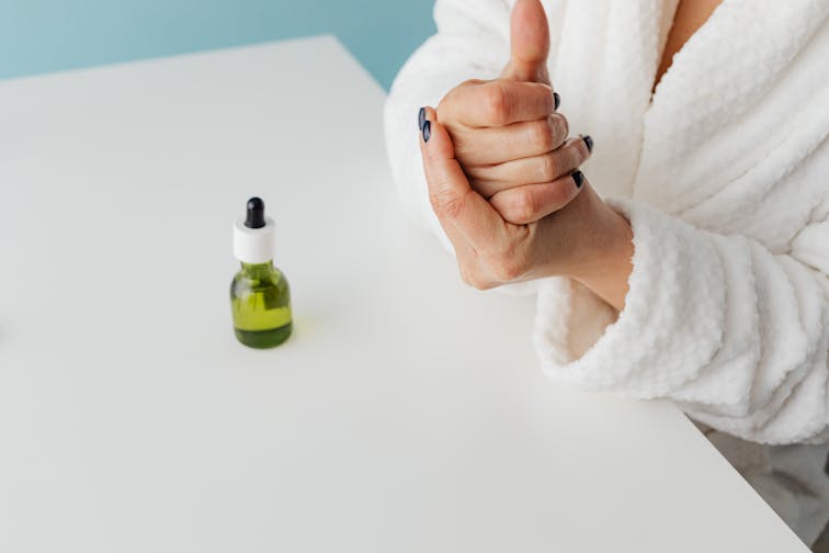 自宅でスキンケアを丁寧に行う女性。化粧水を手のひらで温めてから肌にのせる様子