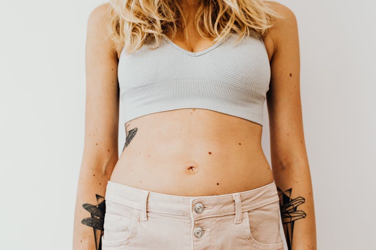 EMSパッドをお腹に装着して施術を受けている女性。リラックスした姿勢で横になっている